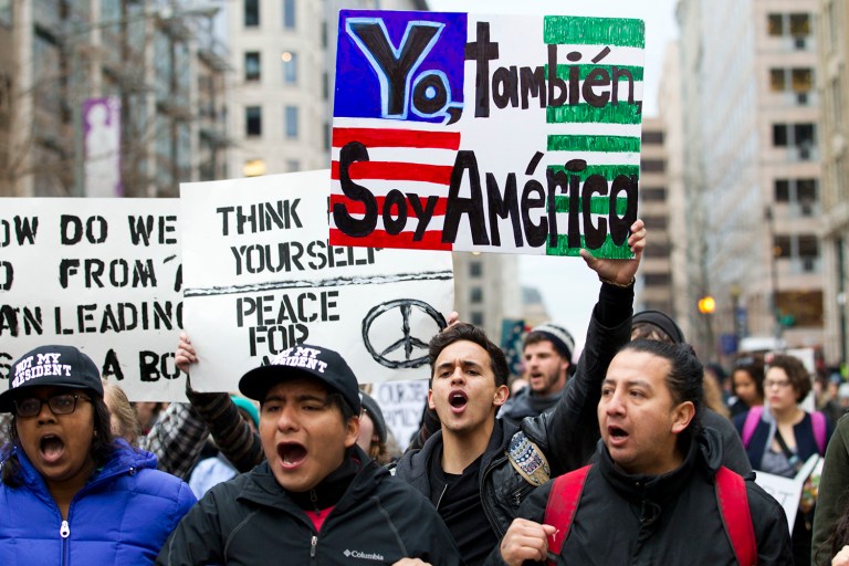 Demonstrators march on the street near a security checkpoint inaugural entrance, Friday, Jan. 20, 2017 in Washington, ahead of President-elect Donald Trump's inauguration.