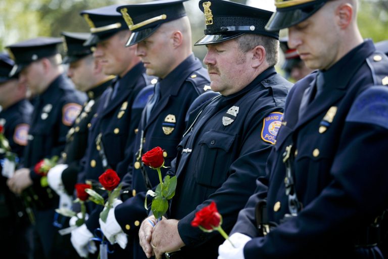 In this Thursday, May 11, 2017 photo, Grand Rapids police officers attends a memorial in honor of Grand Rapids' fallen officers, including officer Robert Kozminski, in Richmond Park in Grand Rapids, Mich. (Daytona Niles/The Grand Rapids Press via AP)