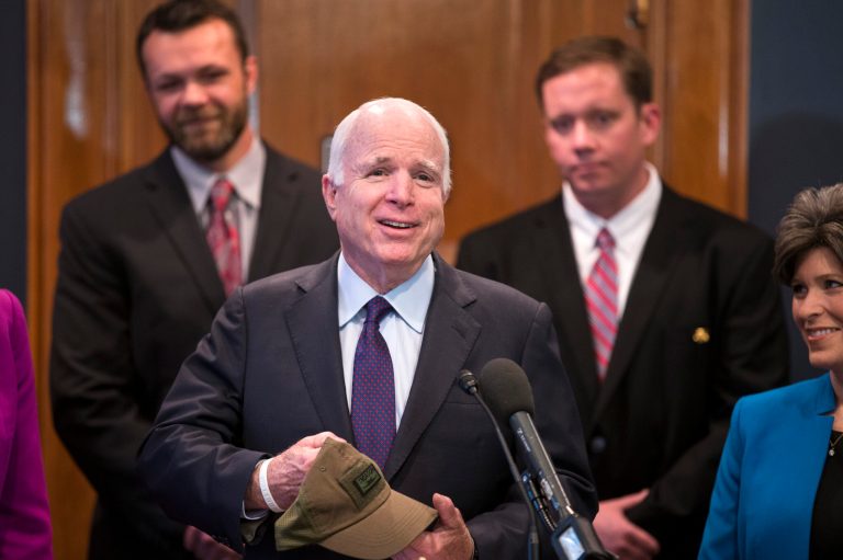 Senate Armed Services Committee Chairman Sen. John McCain, R-Ariz. holds a hat with an image of the A-10 aircraft and the word 'treason' given to him prior to a news conference on Capitol Hill in Washington,Tuesday, May 5, 2015, to discuss support of retaining the aircraft. (AP Photo/Brett Carlsen)