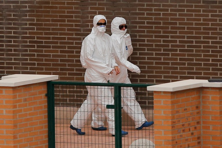 Medical staff wearing protective clothing arrives at the apartment building of the Spanish nurse infected with Ebola in Madrid, Spain, Wednesday, Oct. 8, 2014. Officials said a nurse and a nursing assistant have been placed under observation for Ebola in a Madrid hospital where a colleague became infected after working with two Spanish missionary priests who contracted the disease in West Africa and later died at the center. (AP Photo/Andres Kudacki)