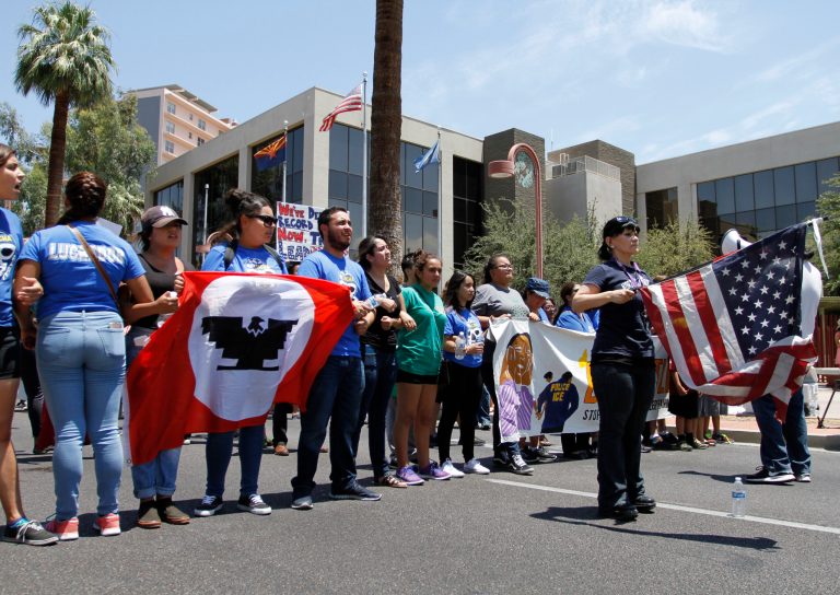 Activists block a major downtown road to protest a Supreme Court decision on immigration Thursday June 23, 2016, in Phoenix Arizona. The crowed gathered outside the U.S. Immigration and Customs Enforcement building in Phoenix to voice dismay at the Supreme Court decision blocking President Barack Obama's plan to shield millions living in the U.S. illegally from deportation. (AP Photo/ Beatriz Costa-Lima)