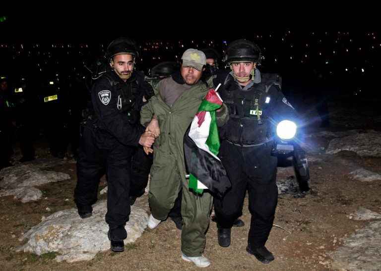Israeli border policemen evict a Palestinian activist from an area known as E1 near Jerusalem, Sunday, March 24, 2013. Palestinian activists erected tents in the E1 area to protest Israeli plans for a new settlement in the area. (AP Photo/Nasser Shiyoukhi)