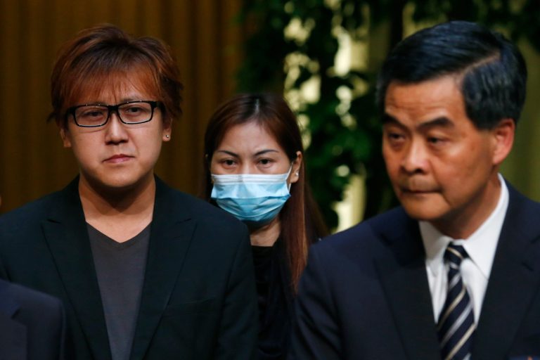 Hong Kong's leader, Chief Executive Leung Chun-ying, right, speaks as hostage survivor Yik Siu-ling, center, and Tse Chi-kin, left, brother of killed hostage victim Masa Tse Ting-chunn listen during a news conference in Hong Kong Wednesday, April 23, 2014. Hong Kong and the Philippines reached a compromise Wednesday over Hong Kong's demands for an apology for the families of eight tourists killed in a bungled response to a 2010 Manila hostage-taking that soured relations. (AP Photo/Kin Cheung)