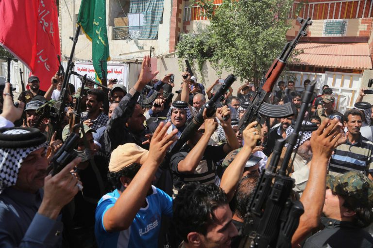 Iraqi Shiite tribal fighters raise their weapons and chant slogans against the al Qaeda inspired Islamic State of Iraq and the Levant (ISIL) in Baghdad's Sadr city, Iraq, Saturday, June 14, 2014. (AP Photo/Karim Kadim)