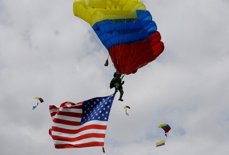 Colombian airborne troops parachute in a show of military exercises at the Tolemaida military base during a visit by U.S. Defense Secretary Chuck Hagel, in Melgar, Colombia, Friday, Oct. 10, 2014. Colombia's was Hagel's first stop on his six-day, three-country trip to South America. Hagel will also travel to Chile and Peru, where he will attend a conference of defense ministers from the Americas. (AP Photo/Fernando Vergara)