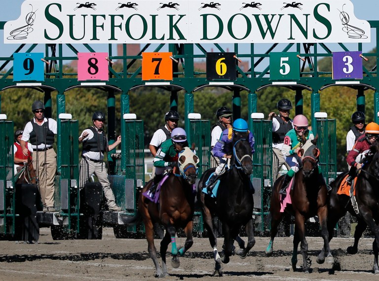 Gate crew members watch the start of a race at Suffolk Downs in Boston, Monday, Sept. 22, 2014. The last thoroughbred horse racing track in New England is closing this year, as the once grand Suffolk Downs yields to growing competition from casinos, lotteries and other forms of gambling. Experts say the local breeding industry could all but vanish. (AP Photo/Elise Amendola)