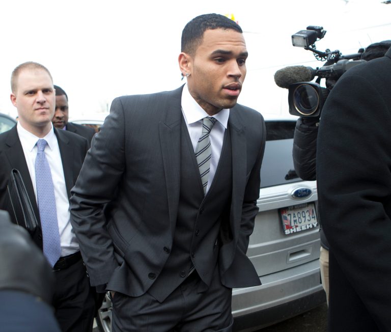 FILE - In this Wednesday, Jan. 8, 2014 file photo, singer Chris Brown, right, arrives at the District of Columbia Superior Court in Washington, for a status hearing in a case in which he's accused of hitting a man outside a Washington hotel. Lawyers for Brown are due back in a Washington court Thursday Feb. 20, 2014 to determine a date for his trial on a misdemeanor assault charge, but the singer won't be in town.  (AP Photo/Manuel Balce Ceneta, File)