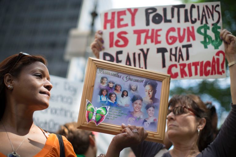 Diana Rodriguez, of Staten Island, holds a framed image of her daughter Samantha Guzman who was a victim of gun violence, at a rally outside city hall to call for tougher gun control laws, in New York. (AP Photo/John Minchillo)