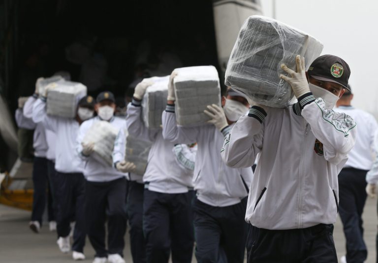 Police carry blocks of seized cocaine as they present it to the press at a police base in Lima, Peru, Monday, Sept. 1, 2014. Police announced that they seized 7.6 tons of cocaine in the northern town of Trujillo on Aug. 26, and that it's the largest seizure of cocaine in Peru's history. (AP Photo/Martin Mejia)