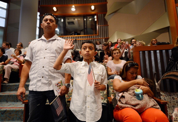 LOS ANGELES, CA - SEPTEMBER 19:  U.S. citizenship candidate Ricardo Barrera, 8, takes the oath of citizenship as his father Ricardo Barrera (L) mother Reina Barrera and his sister Ashley, 1, look on during a naturalization ceremony at the Los Angeles Central Library on September 19, 2012 in Los Angeles, California. Fifty local children participated in the citizenship ceremony. In recognition of Constitution Day and Citizenship Day, over 32,000 new citizens will be welcomed by U.S. Citizenship and Immigration Services from September 14 to September 22.  (Photo by Kevork Djansezian/Getty Images)
