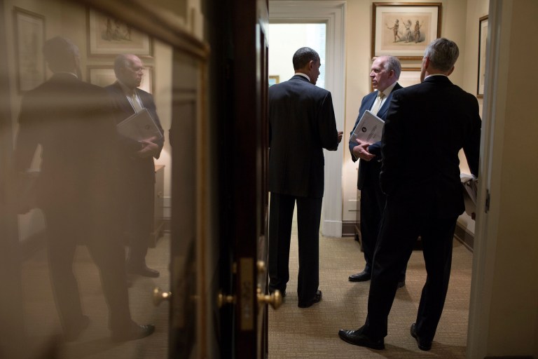 President Obama talks with CIA Director John Brennan, center, and Chief of Staff Denis McDonough in a West Wing hallway of the White House. Brennan is holding a copy of the Senate Intelligence Committee's torture report. (Photo: Pete Souza/White House)