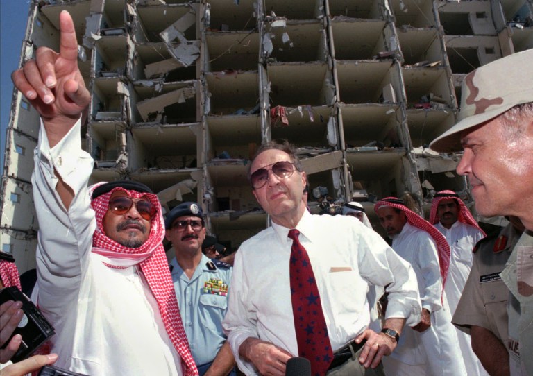 In this June 29, 1996 file photo, then Defense Secretary William Perry, center, listens to then Saudi ambassador to the United States, Prince Bandar bin Sultan, left, at the blast site of the devastated Khobar Towers at a U.S. military base that killed 19 U.S. servicemen in Dhahran, Saudi Arabia. (AP Photo/Saleh Rifai, File)