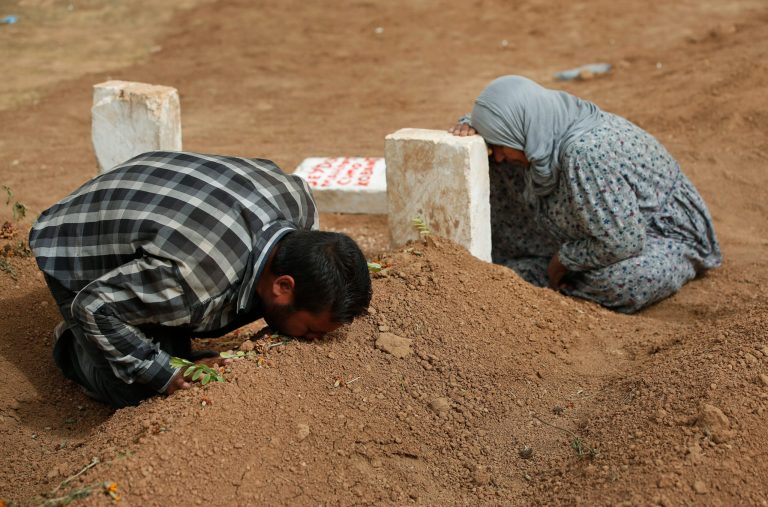 Kurdish Rabia Ali, right, accompanied by her son Ali Mehmud, left, mourn on Saturday, Oct. 11, 2014, at the grave of her son Seydo Mehmud 'Curo' , a Kurdish fighter, who was killed in the fighting with the militants of the Islamic State group in Kobani, Syria, and was buried at a cemetery in Suruc, on the Turkey-Syria border on Tuesday, Oct. 7. Kobani, also known as Ayn Arab, and its surrounding areas, has been under assault by extremists of the Islamic State group since mid-September and is being defended by Kurdish  fighters. (AP Photo/Lefteris Pitarakis)
