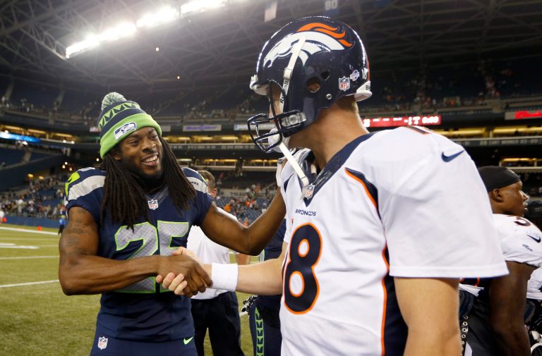 Seattle Seahawks cornerback Richard Sherman, left, shakes hands with Denver Broncos quarterback Peyton Manning after the Seahawks beat the Broncos in a preseason game in Seattle in August 2013. (AP Photo/John Froschauer)