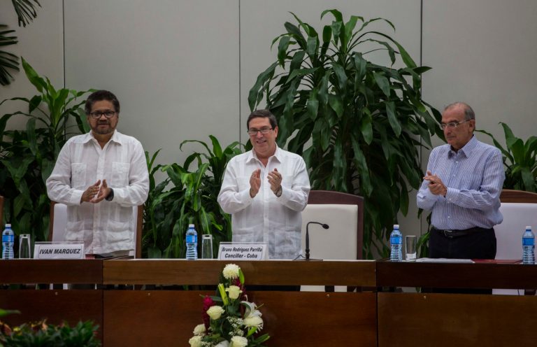 Ivan Marquez, chief negotiator of the Revolutionary Armed Forces of Colombia, or FARC, from left, Cuba's Foreign Minister Bruno Rodriguez, and Humberto de La Calle, head of Colombia's government peace negotiation team, applaud after the signing of the latest text of the peace accord between the two sides in Havana, Cuba, Saturday, Nov. 12, 2016. (AP Photo/Desmond Boylan)