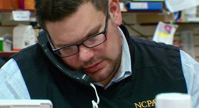 This photo from video taken Oct. 9, 2013, shows Tim Davis on the phone of his pharmacy in New Brighton, Pa. Davis uses several apps and three wearable devices to track his physical activity, vitals and calorie intake. When Davis tipped the scales at 318 pounds two years ago, he bought a Fitbit gadget to track his physical activity and the Lose It! app on his phone to track calories. He bought a Wi-Fi-enabled scale that published his daily weight on his Twitter feed and turned to other apps to track his pulse, blood pressure, daily moods and medications. At one point, Davis said he was using 15 different apps and gadgets, which he said helped him drop 64 pounds by that following year. (AP Photo/Noel Waghorn)