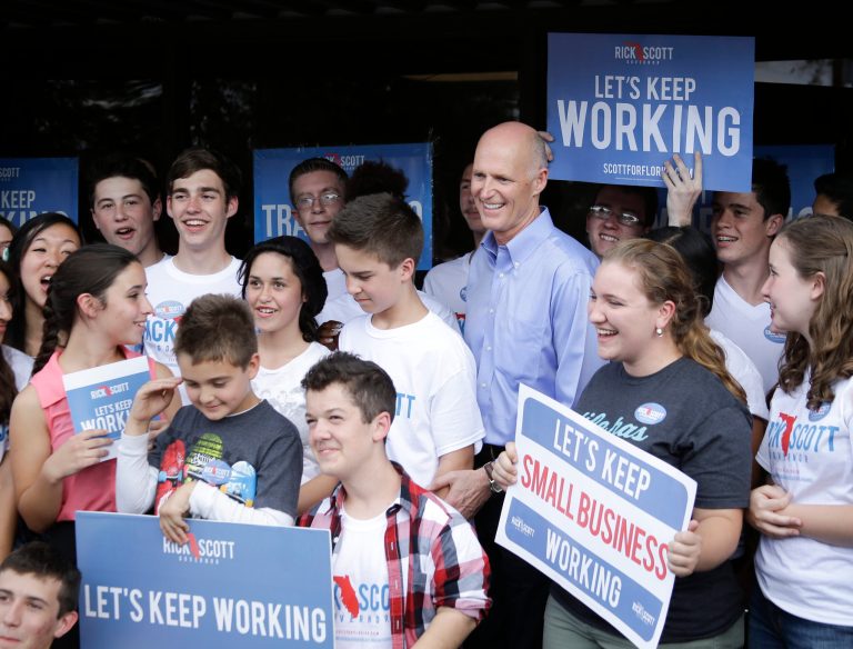 Florida Gov. Rick Scott, third from right, gathers with campaign volunteers for a photo after a visit to a phone bank on election day, Tuesday, Nov. 4, 2014, in Orlando, Fla. (AP Photo/John Raoux)