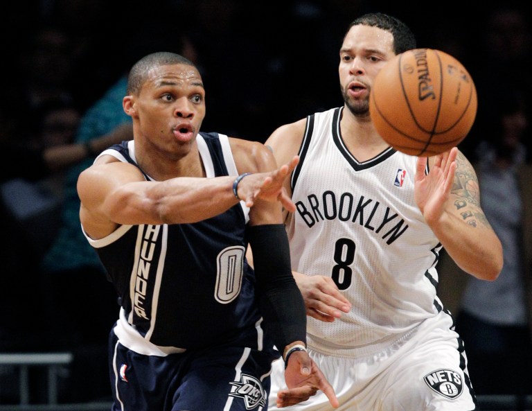   Oklahoma City Thunder guard Russell Westbrook (0) passes as Brooklyn Nets guard Deron Williams (8) defends in the first half of their NBA basketball game at Barclays Center, Tuesday, Dec. 4, 2012, in New York. (AP Photo/Kathy Willens)  