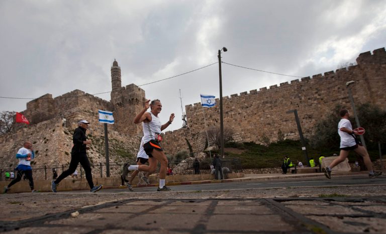 FILE - In this March 16, 2012 file photo, runners are seen passing the Tower of David during the second annual marathon in Jerusalem. The Palestinians called for a boycott since the route includes a segment in the walled Old City - part of their hoped-for capital - while hardline Israeli lawmakers are planning to run it for just the opposite reason, to assert Israeli sovereignty over the entire city (AP Photo/Sebastian Scheiner, File)