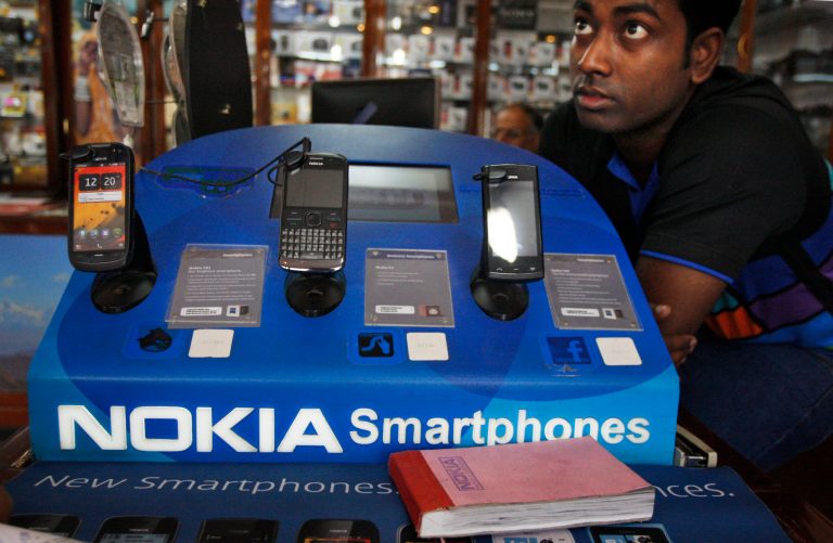   An Indian shopkeeper selling Nokia mobile phones awaits customers in New Delhi, India, Thursday, June 14, 2012. Nokia Corp. will lay off 10,000 jobs globally and close plants by the end of 2013, the company said Thursday, in a further drive to save costs and streamline operations.(AP Photo/Tsering Topgyal)  