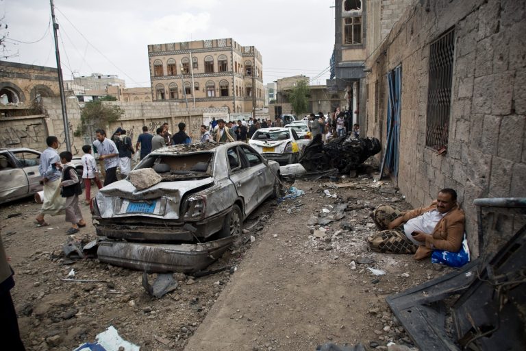 A man rests next to his car destroyed by Saudi-led airstrikes in Sanaa, Yemen, Wednesday, May 27, 2015. In a report Wednesday, World Health Organization Chief Margaret Chan said that Yemen's conflict has left up to 2,000 people dead and 8,000 wounded, including hundreds of women and children. She did not specify how many of the dead were civilian. (AP Photo/Hani Mohammed)