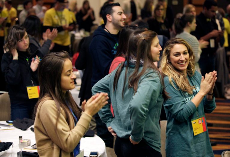 Attendees to Livestrong Foundation's annual meeting cheer as its executive vice president Andy Miller speaks Thursday, Feb. 28, 2013, in Chicago. Leaders of the cancer charity founded by Lance Armstrong said at the first such gathering since Armstrong was engulfed in scandal that the organization will persevere in the wake of the cyclist's admission that he used performance-enhancing drugs. (AP Photo/Kiichiro Sato)