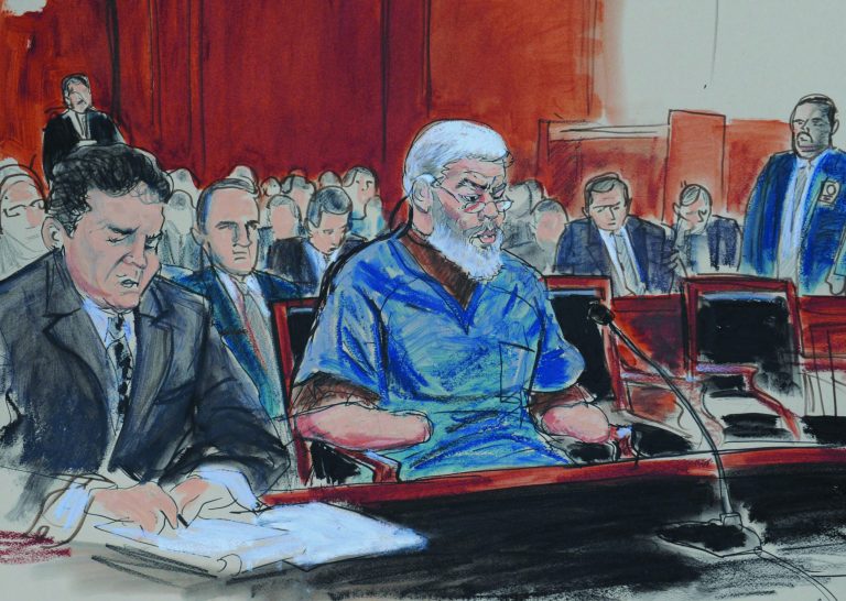 In this courtroom drawing, defense attorney, Jeremy Schneider, left, represents accused terrorist Abu Hamza al-Masri, center, in Manhattan federal court, Tuesday, Oct. 9, 2012, in New York. (AP Photo/ Elizabeth Williams)