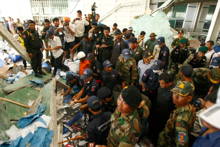 Cambodian rescuers work at the site of a factory collapse in Kai Ruong village, south of Phnom Penh, Cambodia, Thursday, May 16, 2013. The ceiling of the factory that makes Asics sneakers collapsed on workers early Thursday, killing two people and injuring seven, in the latest accident to spotlight lax safety conditions in the global garment industry. (AP Photo/Heng Sinith)