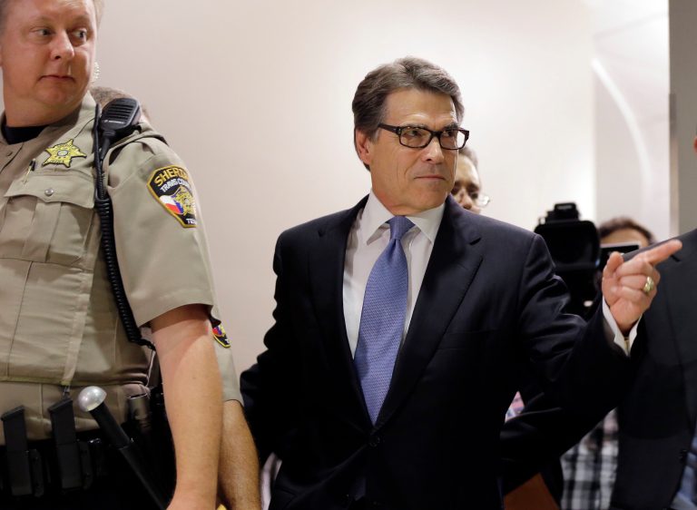 Texas Gov. Rick Perry, right, arrives at the Blackwell Thurman Criminal Justice Center for booking Tuesday in Austin. (AP Photo/Eric Gay)