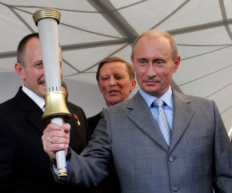 Russian President Vladimir Putin holds one of the torches produced for the 1980 Moscow Olympics during a visit to the Klimov Aircraft Engines Corporation in St. Petersburg, Russia, in August 2007. (AP Photo/Alexander Zemlianichenko, File)