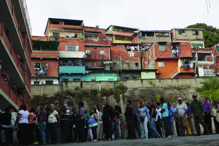 Residents wait in line at a polling station to vote in the presidential election in the Catia neighborhood of Caracas, Venezuela, Sunday, Oct. 7, 2012. President Hugo Chavez is running for re-election against opposition candidate Henrique Capriles. (AP Photo/Rodrigo Abd)