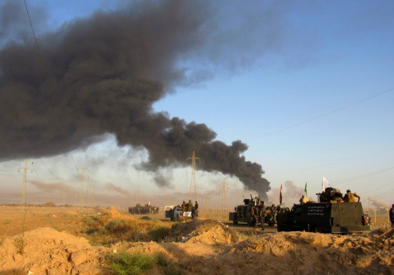 Smoke rises from Islamic State group positions after an airstrike by U.S.-led coalition warplanes in Fallujah, as Iraqi security forces and allied Shiite Popular Mobilization Forces and Sunni tribal fighters, take combat positions outside Fallujah, 40 miles (65 kilometers) west of Baghdad, Iraq, Monday, May 23, 2016.