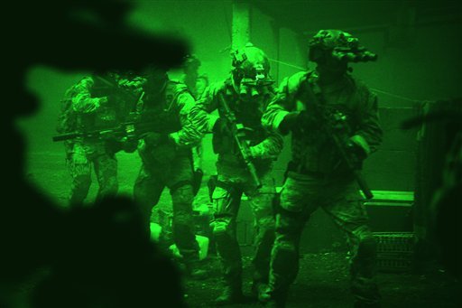 This undated publicity photo released by Columbia Pictures Industries, Inc. shows Navy SEALs seen through the greenish glow of night vision goggles, as they prepare to breach a locked door in Osama Bin Laden's compound in Columbia Pictures' hyper-realistic new action thriller from director Kathryn Bigelow, 