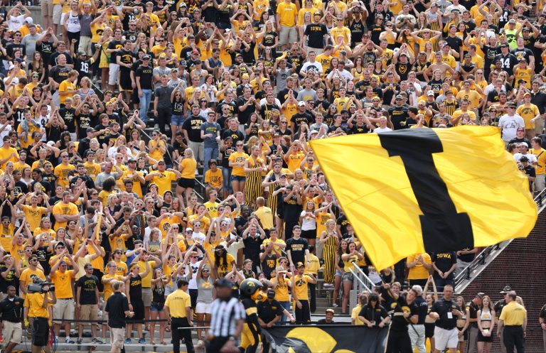 In this photo taken on Saturday, Aug. 30, 2014, the Iowa student section cheers during the second half of an NCAA college football game against Northern Iowa in Iowa City, Iowa. In an attempt to lure students to seats, the University of Iowa recently tried its most desperate promotion yet: A raffle for free tuition if a student purchased a book of season tickets. (AP Photo/Justin Hayworth)