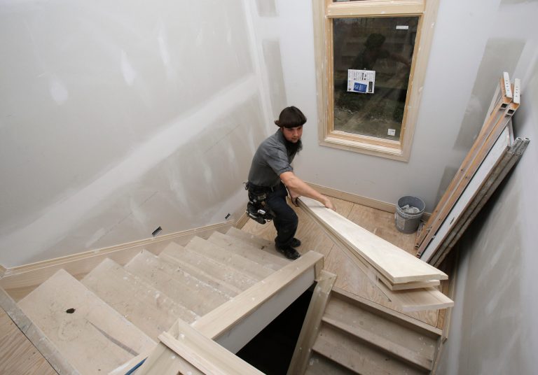 In this Monday, Nov. 11, 2013 photo, Will Hostetler, a carpenter with Larry Block Builders, carries trim downstairs at a new home under construction, in Pepper Pike, Ohio. The Commerce Department reports on the number of permits requested in October and September to build homes, on Tuesday, Nov. 26, 2013. (AP Photo/Tony Dejak)