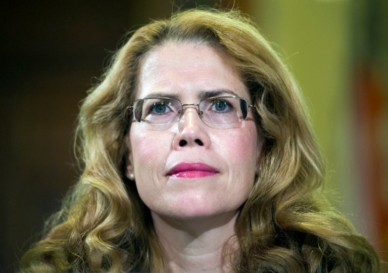 FILE - In this July 8, 2014 file photo, Katherine Mitchell, M.D., medical director, Iraq and Afghanistan Post-Deployment Center, Phoenix VA Health Care System, testifies on Capitol Hill in Washington. The Veterans Affairs Department has reached financial settlements with three employees who faced retaliation after filing whistleblower complaints about the troubled Phoenix VA hospital. The employees were among the first to report widespread wrongdoing at the Phoenix hospital, including chronic delays for veterans seeking care and falsified waiting lists covering up those delays. Similar problems soon were identified across the country amid a growing scandal that forced the ouster of former VA Secretary Eric Shinseki.  (AP Photo/Cliff Owen, File)