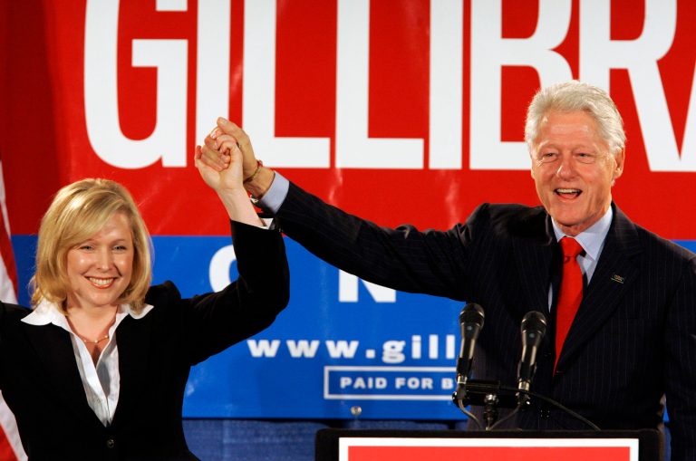 FILE- In this Oct. 26, 2006 file photo, former President Bill Clinton holds up the hand of Kirsten Gillibrand, a Democratic lawyer who is running against three-term Rep. John Sweeney, R-N.Y., at a rally in Albany, N.Y. U.S. Sen. Kirsten Gillibrand said, in an interview in The New York Times, that former President Clinton should have resigned over his sexual affair with White House intern Monica Lewinsky 20 years ago. (AP Photo/Jim McKnight, File)