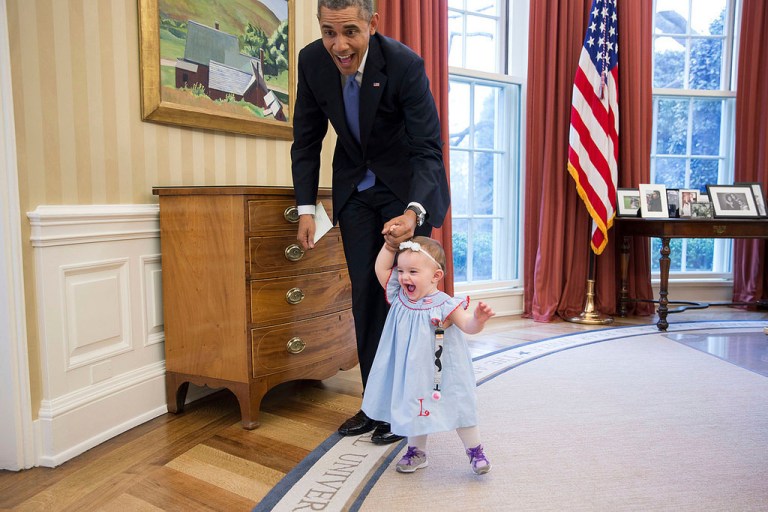 President Obama walks with Lincoln Rose Pierce Smith, the daughter of former deputy press secretary Jamie Smith, in the Oval Office. (Official White House Photo by Pete Souza/White House flickr stream)