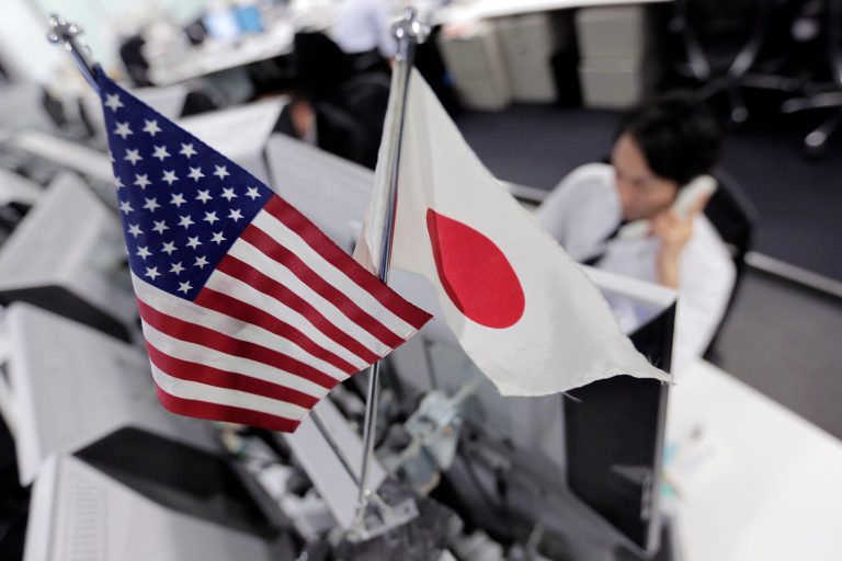   Money traders work under flags of the United States and Japan at a foreign exchange firm in Tokyo Friday, Dec. 21, 2012. The dollar was little changed against other major currencies as traders await developments from budget talks in Washington. (AP Photo/Itsuo Inouye)  