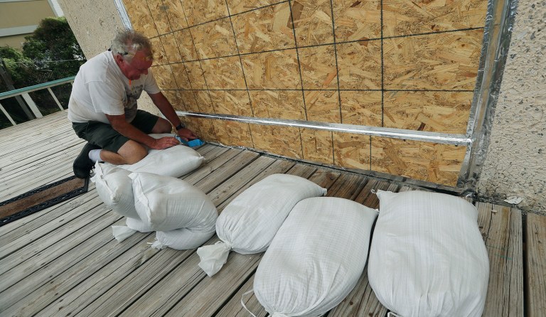 Richard Fine makes final preparations boarding up and sand bagging a beach front home before Hurricane Irma arrives on Saturday, Sept. 9, 2017, at Tybee Island, Ga. (Curtis Compton/Atlanta Journal-Constitution via AP)