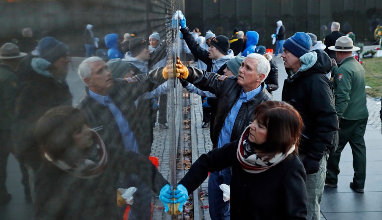 Vice President Mike Pence, with his wife Karen Pence, foreground and Interior Secretary Ryan Zinke clean a portion of the wall at the Vietnam Veterans Memorial on Veterans Day, Saturday, Nov. 11, 2017 in Washington. (AP Photo/Alex Brandon)