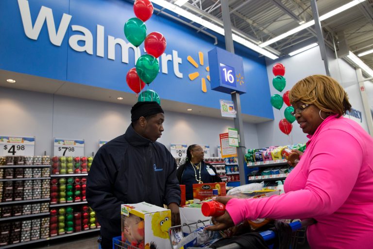FILE - In this Dec. 4, 2013 file photo, April Taylor, of Upper Marlboro, Md., right, buys items with her son Jarhon Taylor, left, on the opening day of a new Wal-Mart store in Washington. The world's largest retailer on Wednesday, June 4, 2014 said that it's expanding Savings Catcher, its online tool that compares prices on thousands of products with those of some of its competitors to cities nationwide in the next few months. (AP Photo/Jacquelyn Martin, File)