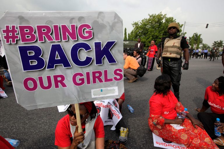 A police officer stands guard as people attend a demonstration calling on the government to rescue the kidnapped girls of the government secondary school in Chibok, in Abuja, Nigeria, on May 22. (AP/Sunday Alamba)