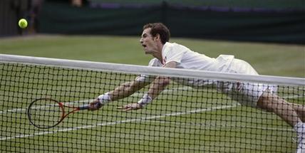 Andy Murray of Britain dives for a shot to Jo-Wilfried Tsonga of France during a men's semifinals match at the All England Lawn Tennis Championships at Wimbledon, England, Friday, July 6, 2012. (AP Photo/Alastair Grant)