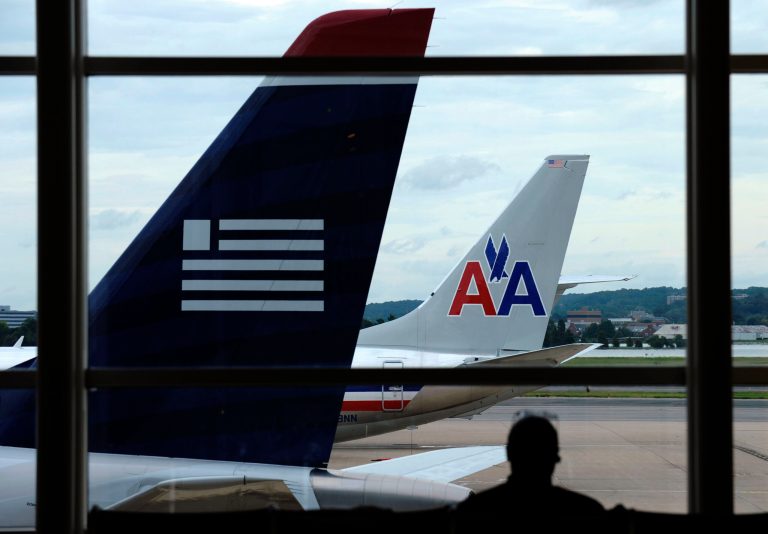 FILE-  In this Tuesday, Aug. 13, 2013, file photo, an American Airlines plane and a US Airways plane are  parked at Washington's Ronald Reagan National Airport in Washington.American Airlines reports quarterly earnings on Tuesday, Jan. 28, 2014. (AP Photo/Susan Walsh, File)
