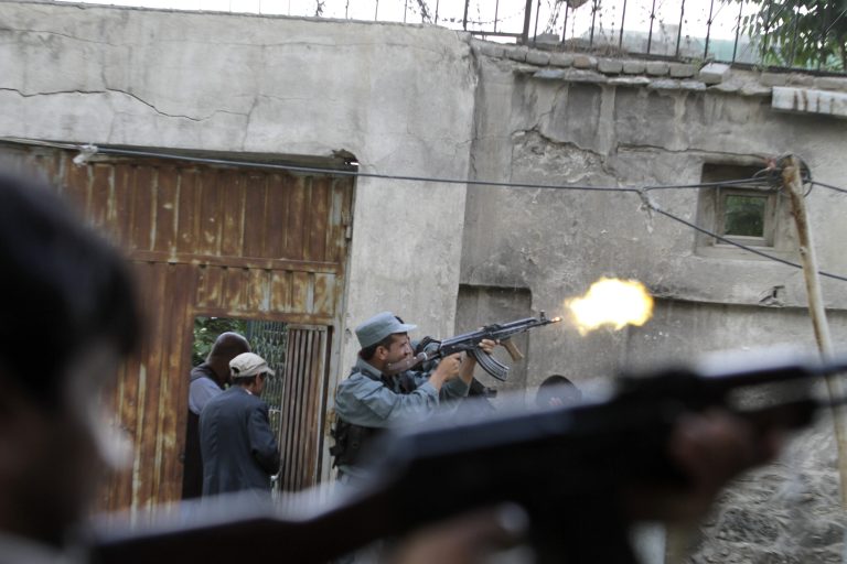 An Afghan policeman fires his weapon during a gunbattle following a suicide attack in Kabul, Afghanistan, Friday, May 24, 2013. A suicide bomber struck in the heart of the Afghan capital on Friday, sending a plume of smoke billowing over Kabul and setting up a gunbattle in the second major attack in the city in little over a week, police said. (AP Photo/Ahmad Jamshid)