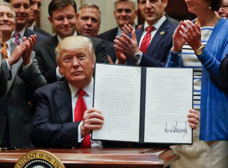 President Donald Trump holds up a signed Executive Order in the Roosevelt Room of the White House in Washington, Friday, April 28, 2017, directing the Interior Department to begin review of restrictive drilling policies for the outer-continental shelf. (AP Photo/Pablo Martinez)