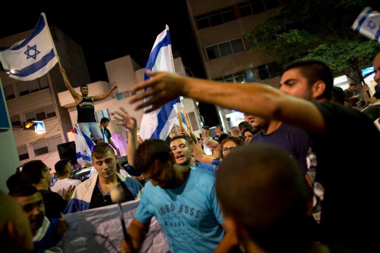 An Israeli activist waves the Israeli flag in support of Israel's operation in Gaza, during a demonstration in Tel Aviv, in this file photo taken Saturday, July 19, 2014. (AP Photo/Oded Balilty, File)