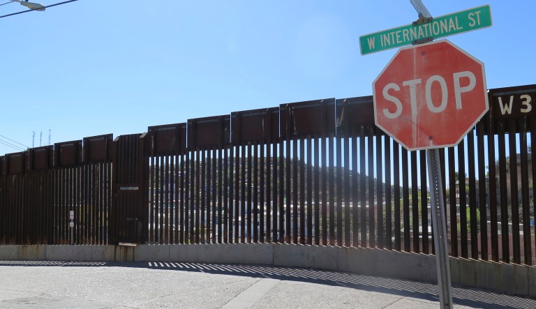 This March 9, 2016, file photo, shows a stop sign in front of the international border fence in Nogales, Ariz. 