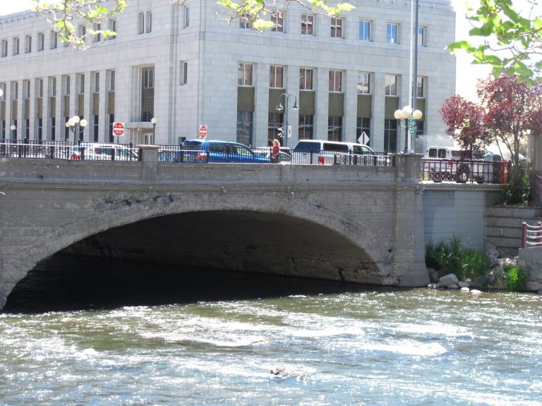 Pedestrians and traffic cross the Truckee River in Reno, Nev., Tuesday, May 27, 2014, on the historic Virginia Street bridge. Built in 1905, demolition and reconstruction of the bridge has been postponed perhaps into next year due to a delay in federal permitting for a comprehensive flood control project. The bridge became legendary after it was portrayed by Hollywood and the news media as the site where people tossed wedding rings into the Truckee after securing divorces at the nearby courthouse.  (AP Photo/By Scott Sonner).